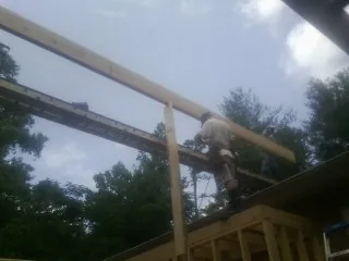 Carpenter setting a ridge beam over a new addition frame — Ice Dam Removal by Roofing Brothers in Jobstown